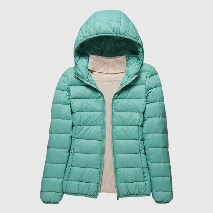 Mint green lightweight quilted hooded jacket with a full-length zip, layered over a beige turtleneck sweater.