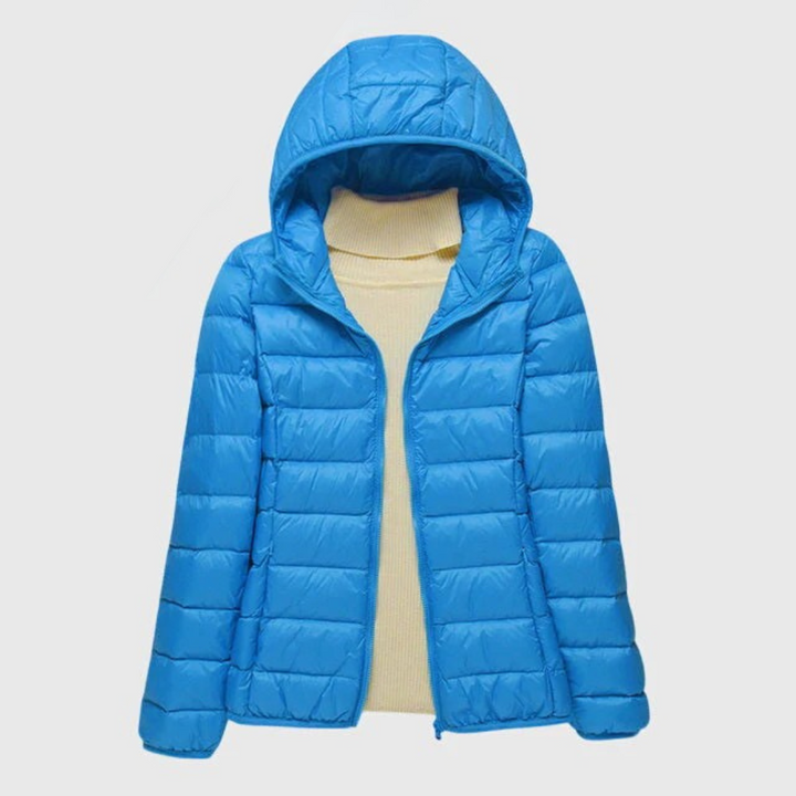 Bright blue lightweight quilted hooded jacket with a full-length zip, layered over a cream ribbed turtleneck sweater.