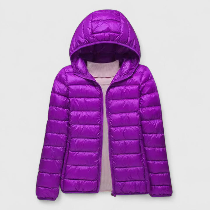 Women's bright purple lightweight quilted jacket with a hood and full-length zip, styled over a light pink top.