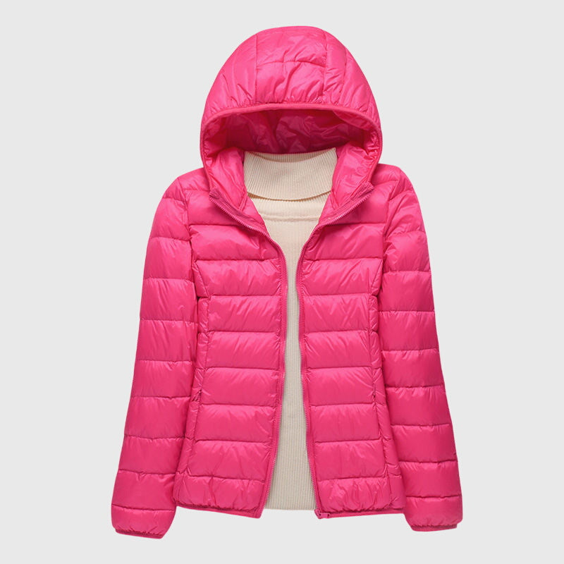 Bright pink lightweight quilted hooded jacket with a full-length zip, layered over a cream turtleneck sweater.