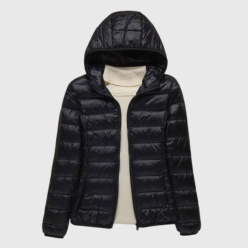 Black lightweight quilted hooded jacket with a full-length zip, layered over a cream turtleneck sweater.