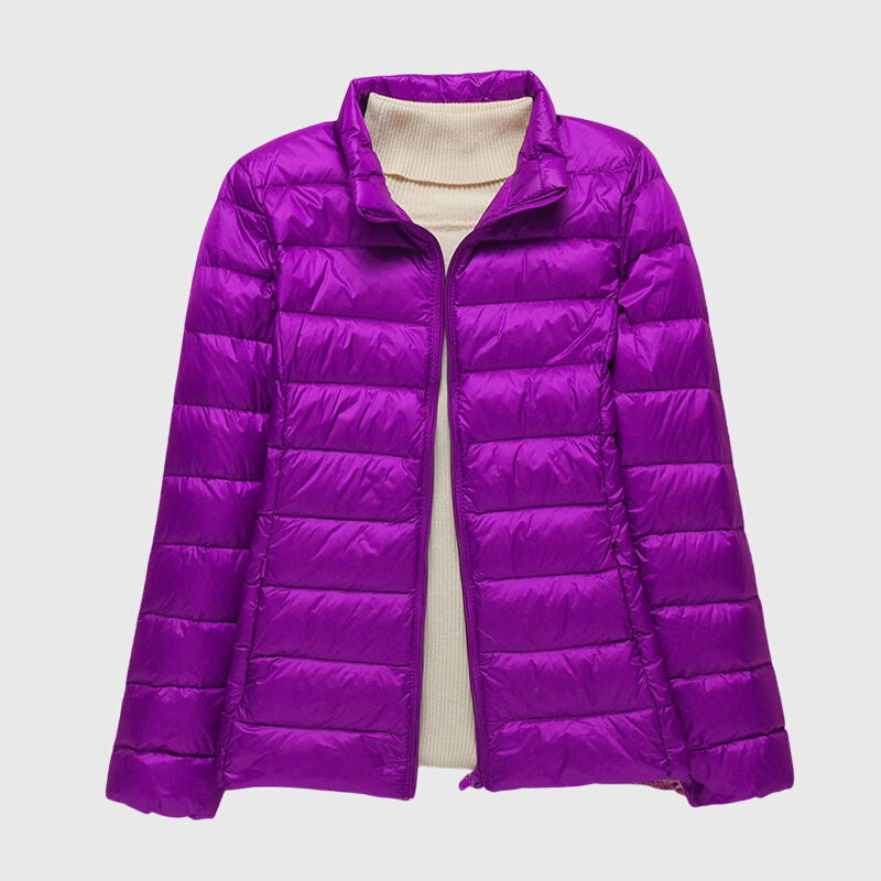 Bright purple lightweight quilted jacket with a zip-up front, layered over a cream-colored ribbed turtleneck sweater.