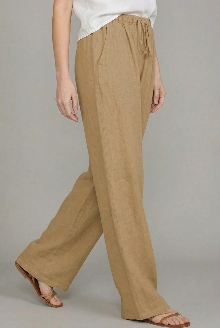 Tan linen wide-leg trousers with an elasticated drawstring waist and side pockets, styled for a relaxed fit.