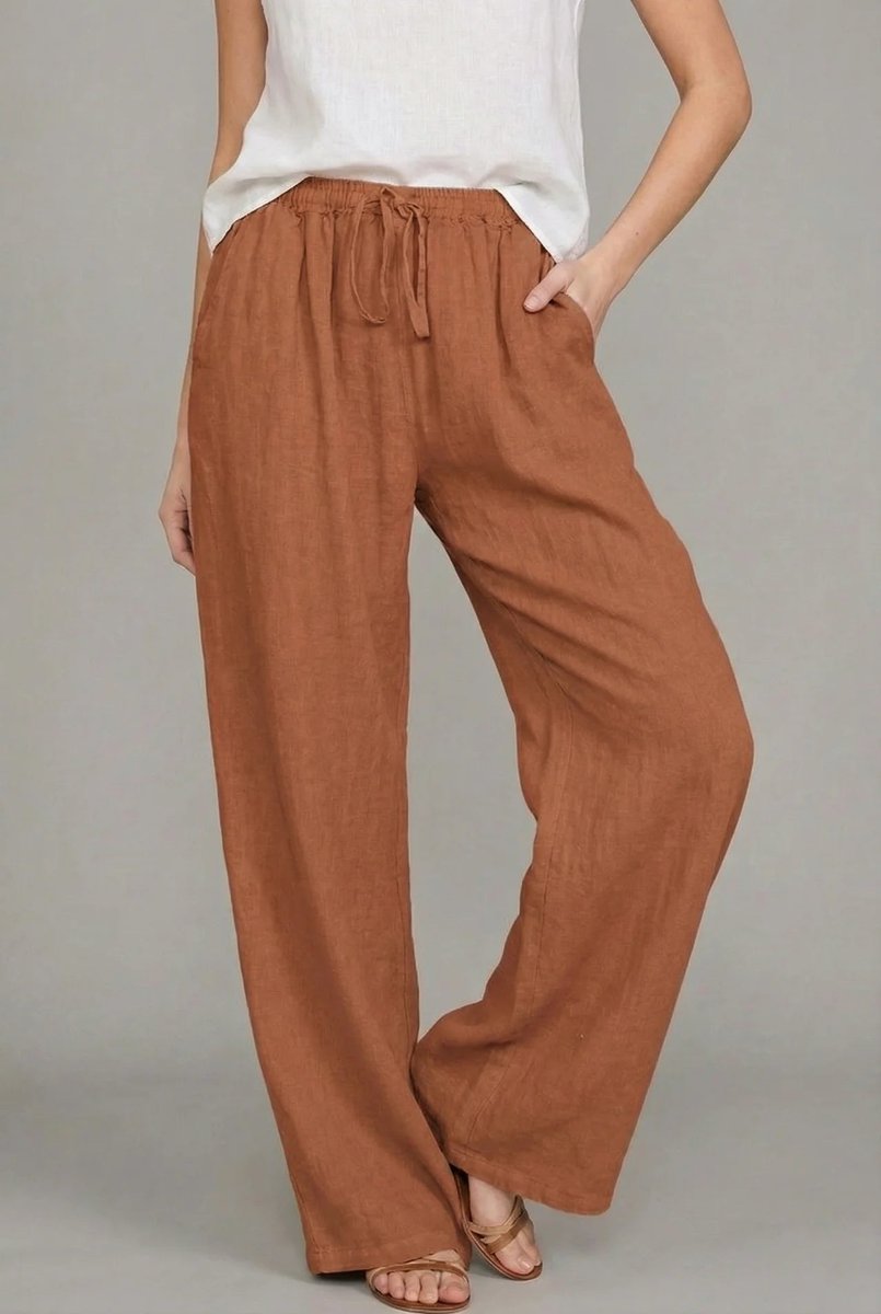 Rust-colored wide-leg linen trousers with an elasticated drawstring waist and side pockets.