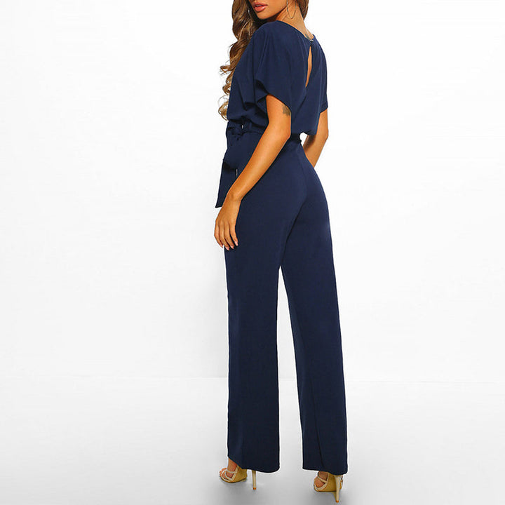 Grace navy tie-waist wide-leg jumpsuit with draped short sleeves, perfect for refined everyday dressing.