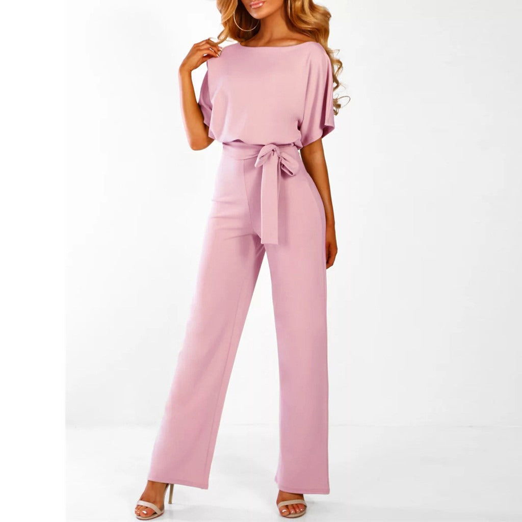 Grace women's pink tie-waist wide-leg jumpsuit with draped short sleeves and elegant heels.