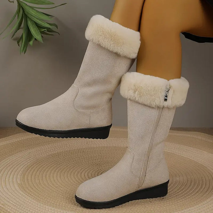 Beige mid-calf winter boots with plush faux fur cuffs, side zip closure, and a black textured sole.