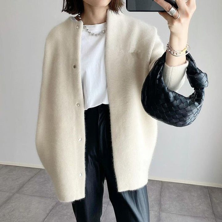 Cream oversized longline cardigan with a collarless neckline, dropped shoulders, and soft brushed knit texture.