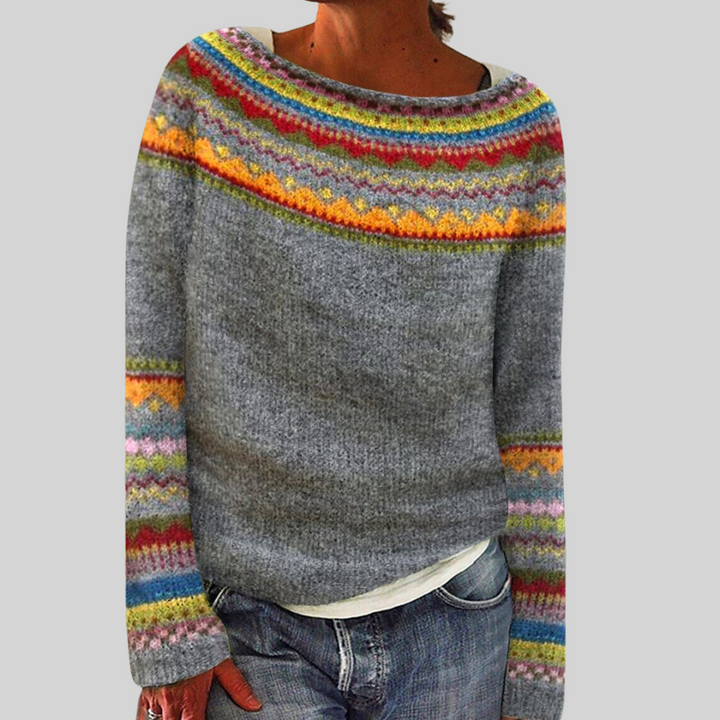 Grey Nordic knit jumper with a wide boat neckline and vibrant, multi-colored patterned detailing on the yoke and sleeves.