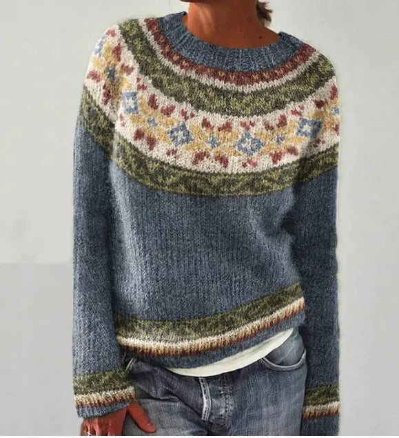 Blue Nordic knit jumper with a colourful patterned yoke, long sleeves, and a relaxed fit worn with jeans.