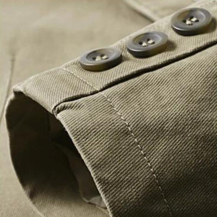 Close-up of a tan cotton casual blazer sleeve featuring three dark buttons and detailed stitching.