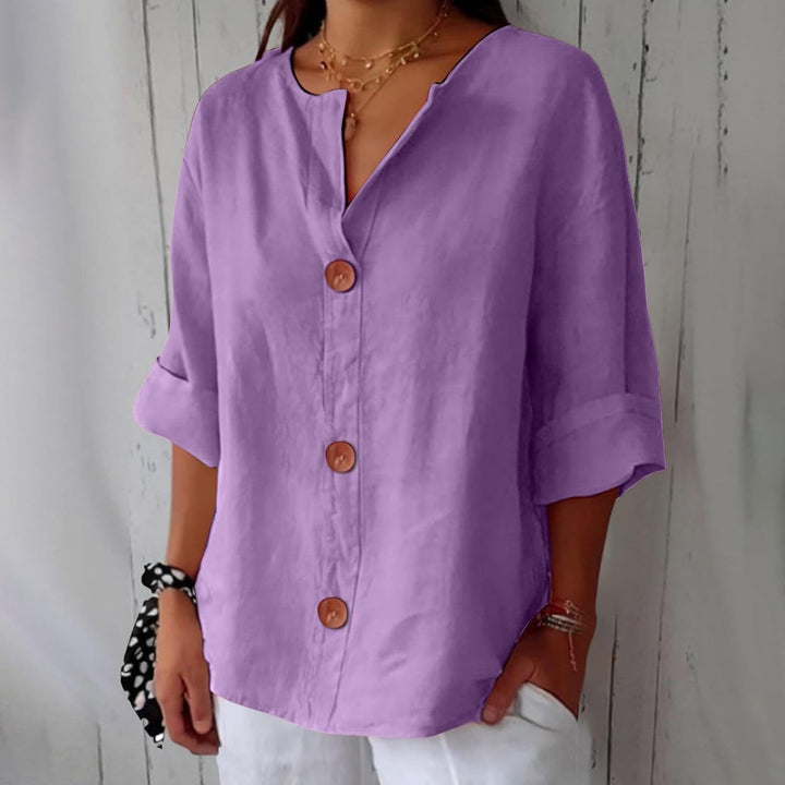 Purple linen V-neck blouse with wooden buttons and rolled three-quarter sleeves in a relaxed, loose fit.
