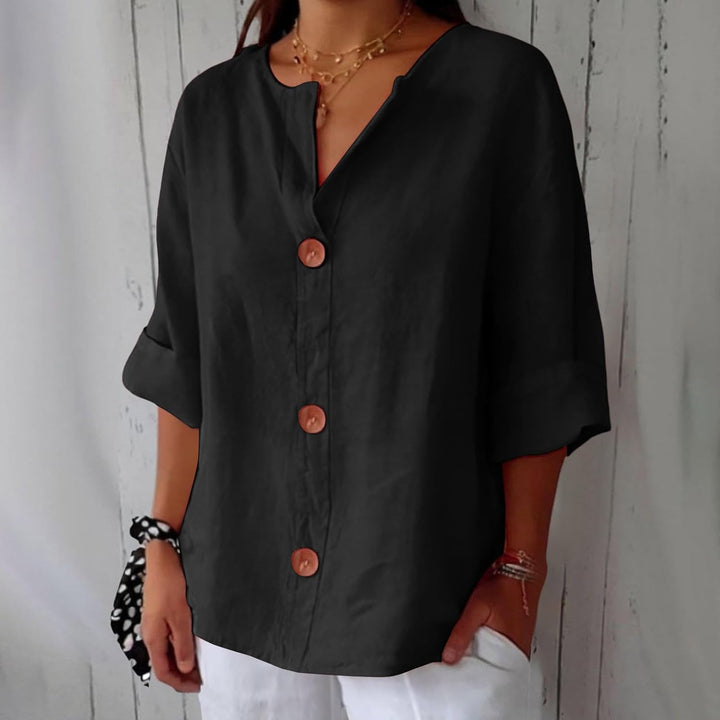 Black linen V-neck blouse with three-quarter rolled sleeves and statement wooden buttons in a relaxed, loose fit.