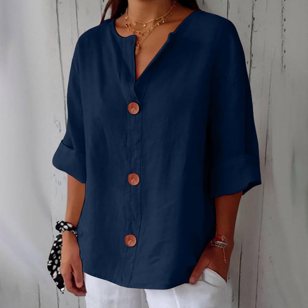 Navy blue linen V-neck blouse with wooden buttons and relaxed three-quarter sleeves.