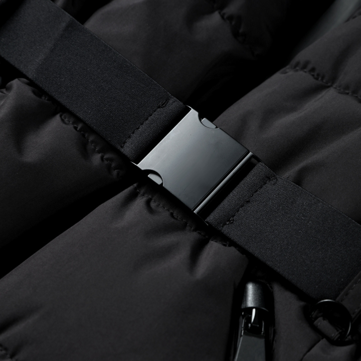 Close-up of a black quilted puffer jacket featuring a sleek, adjustable waist belt with a matching black buckle.