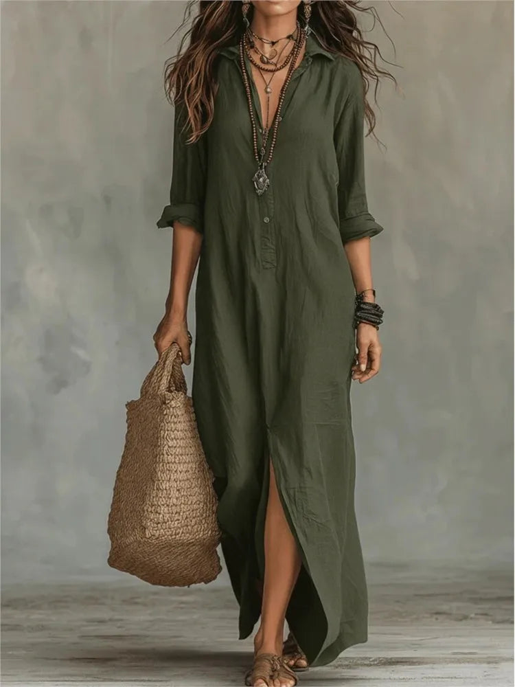 Olive green linen maxi shirt dress with a collared neckline, half-button front, and side slit, styled with a straw bag.