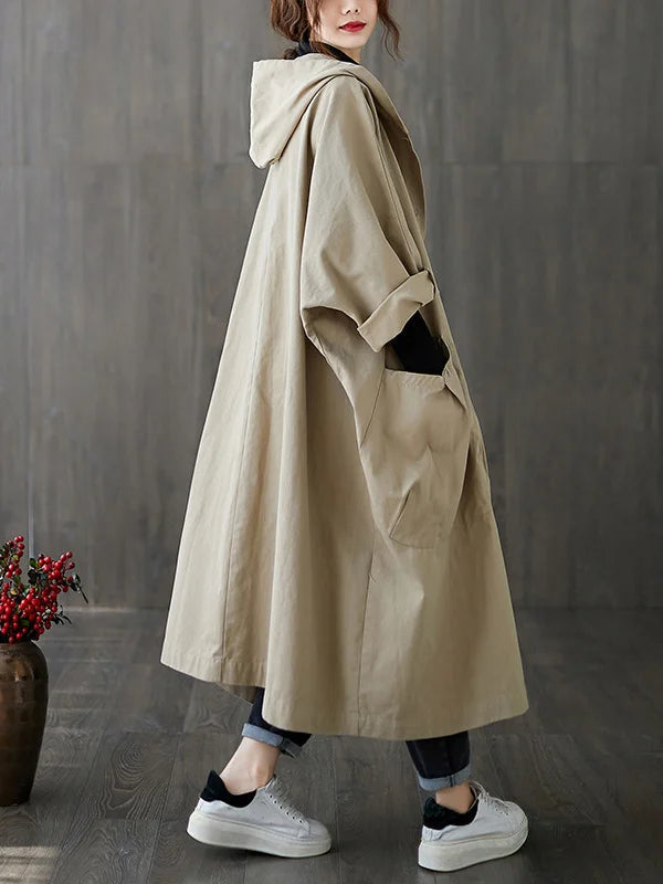 Beige longline hooded coat with an oversized, relaxed fit, deep patch pockets, and cuffed sleeves.