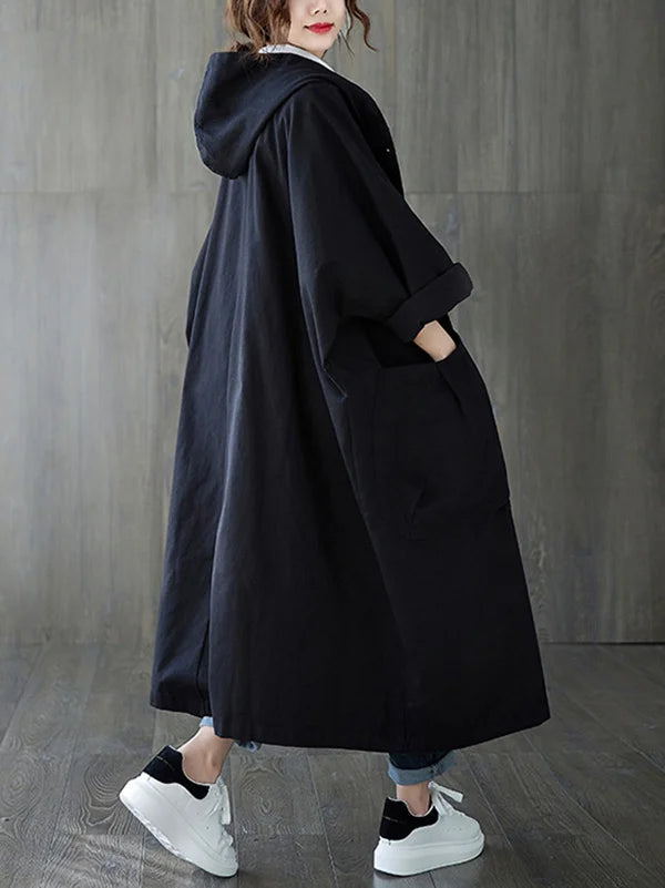 Relaxed black longline hooded coat with oversized fit and large front patch pockets.