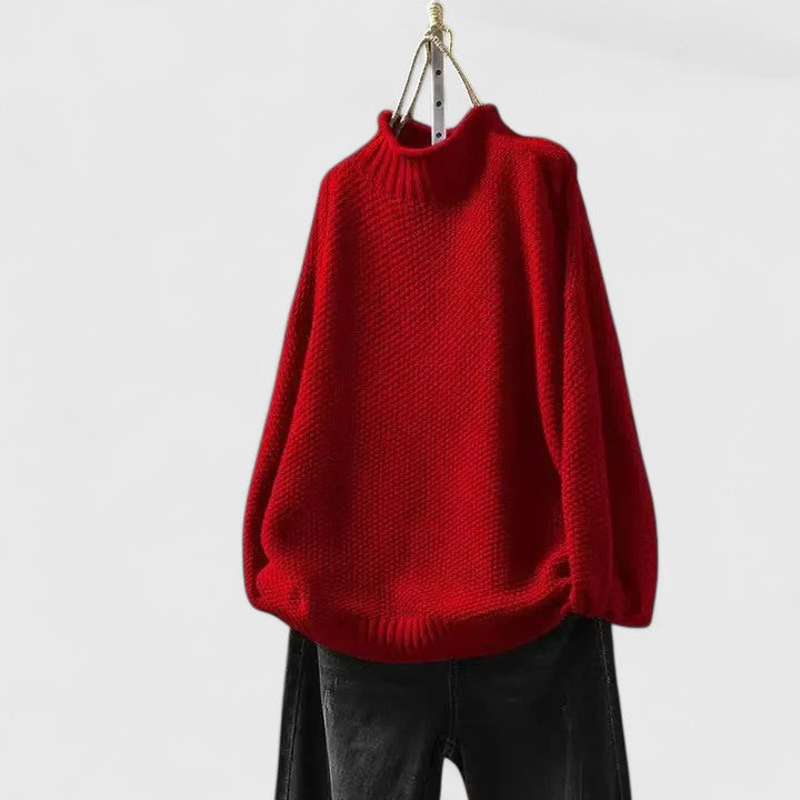 Bright red mock neck knitted jumper with a textured finish, dropped shoulders, and ribbed trim, hanging above dark jeans.