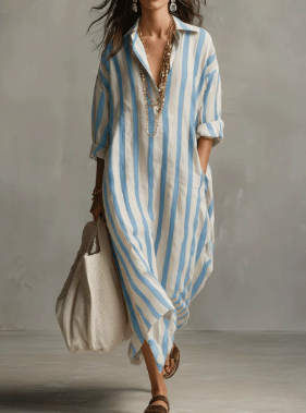 Woman wearing a relaxed, blue and white vertical striped linen maxi shirt dress with a collar and button placket.