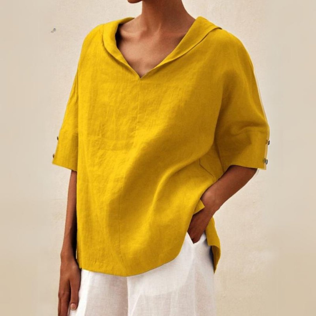 Mustard yellow linen-look V-neck blouse with a draped collar and half-length sleeves featuring button cuff details.