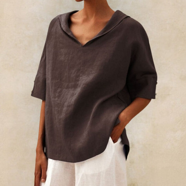 Dark brown linen-look V-neck blouse with a draped collar and half-length sleeves featuring button cuff details.