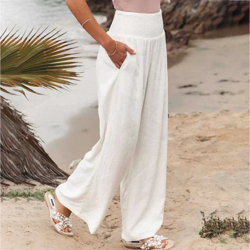 Women's white Iris linen summer trousers with a relaxed fit, elastic waistband, and side pockets, perfect for comfort.