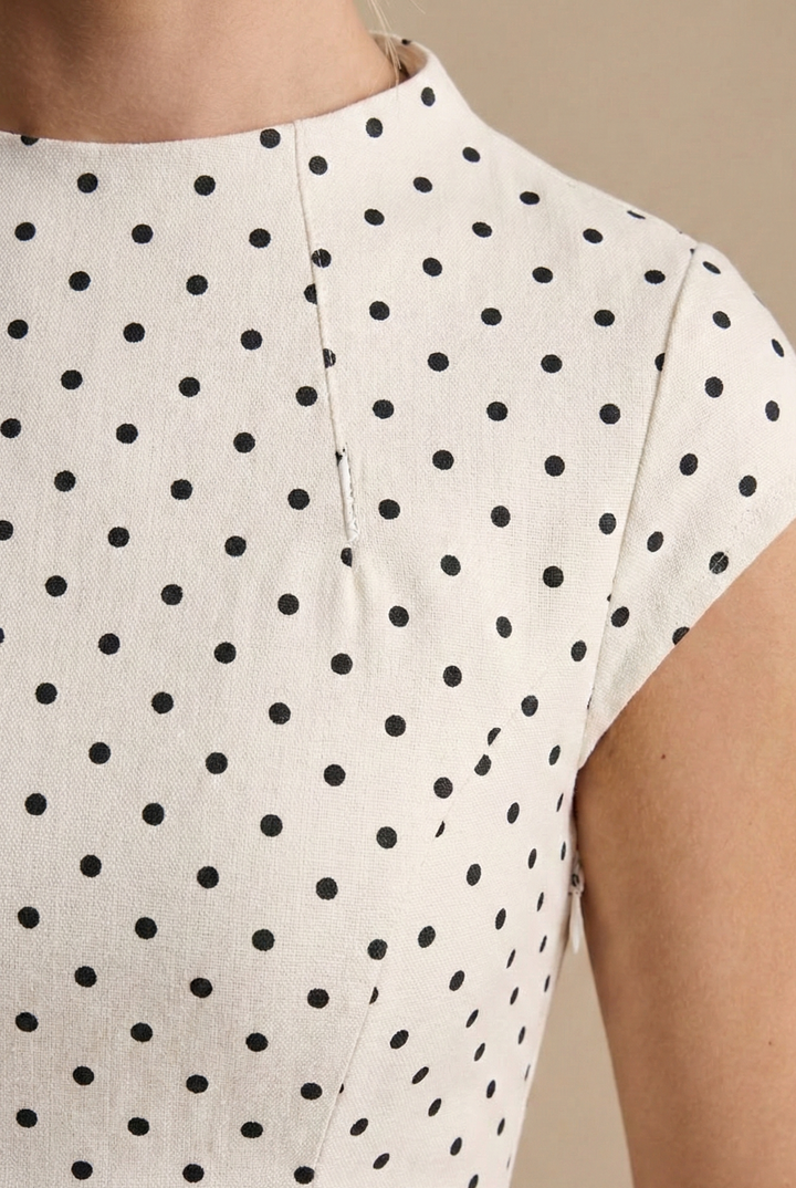 Isabelle women's sleeveless A-line maxi dress in white with a timeless black polka dot pattern.