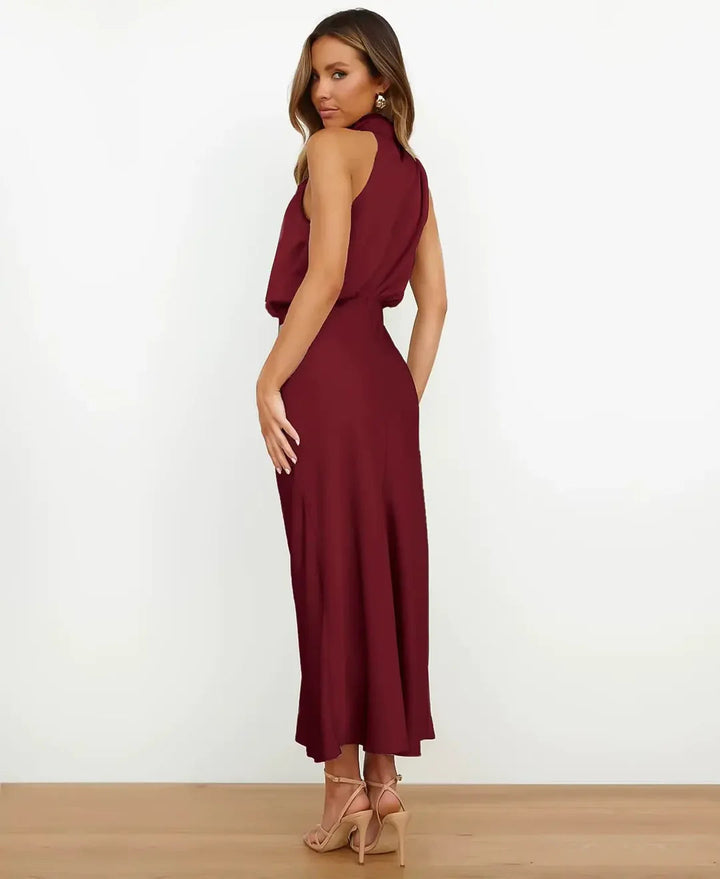 Burgundy satin halter maxi dress with a draped blouson bodice and floor-skimming silhouette.