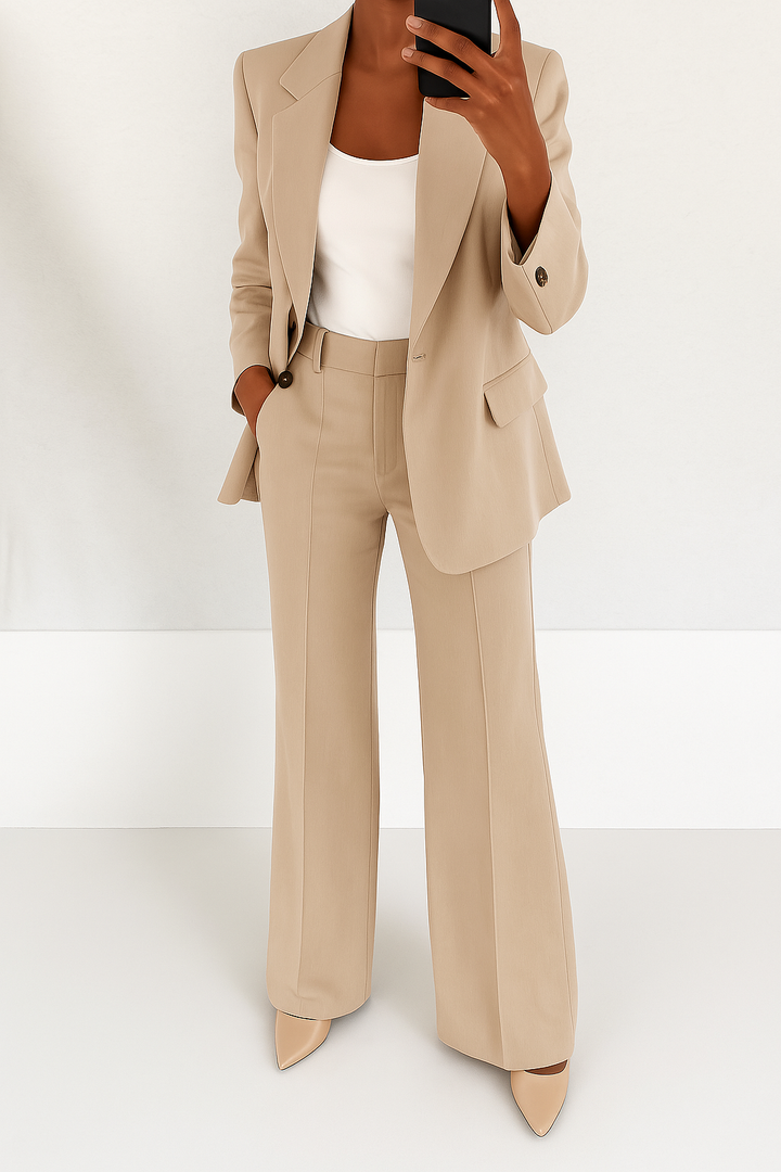 Beige tailored suit set featuring a single-button blazer with peaked lapels and matching straight-leg trousers.