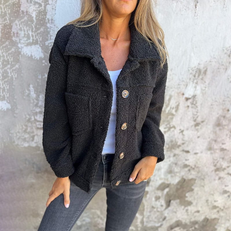 Black plush teddy jacket with a spread collar, button-front closure, and chest pockets in a relaxed, loose fit.