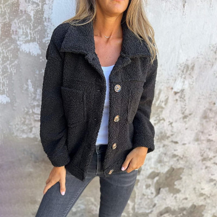 Black plush teddy jacket with a spread collar, button-front closure, and chest pockets in a relaxed, loose fit.