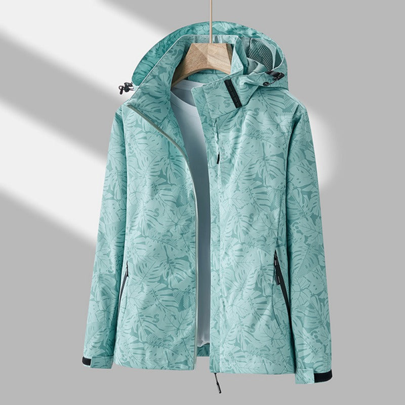 Light green waterproof jacket with a tropical leaf print, featuring an adjustable hood, full-length zip, and side pockets.
