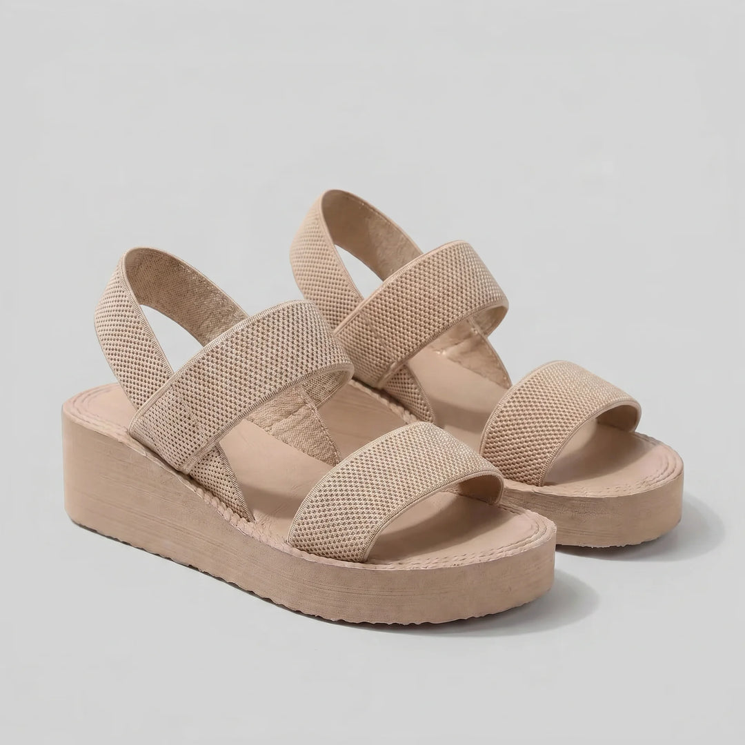 Beige wedge sandals on a light gray background