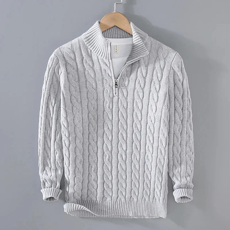 Light grey cable-knit men's jumper featuring a half-zip funnel neck, ribbed cuffs, and hem on a wooden hanger.