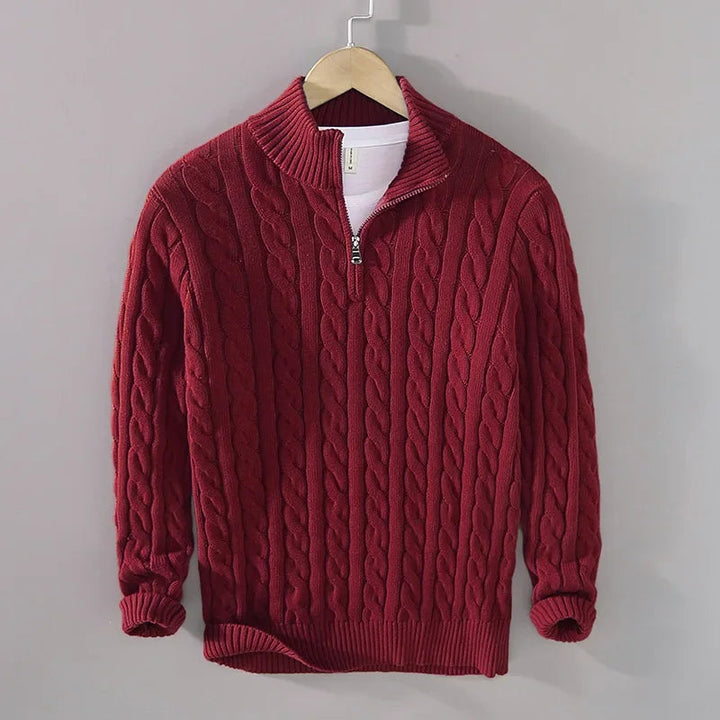 Deep red men's cable-knit jumper featuring a half-zip funnel neck, ribbed cuffs, and hem, hanging on a hanger.