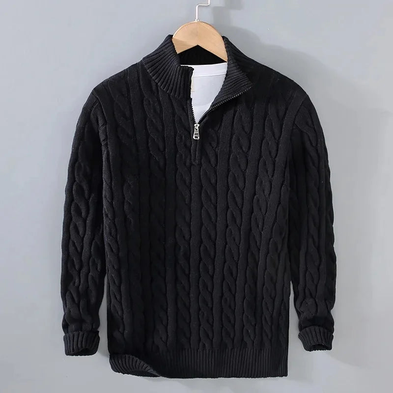 Black men's cable-knit jumper with a half-zip funnel neck, ribbed cuffs, and hem, hanging on a wooden hanger.