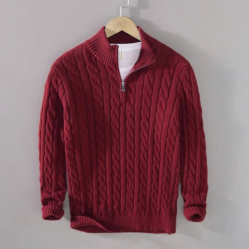 Men's burgundy cable-knit half-zip jumper with a ribbed funnel collar, cuffs, and hem, hanging on a wooden hanger.