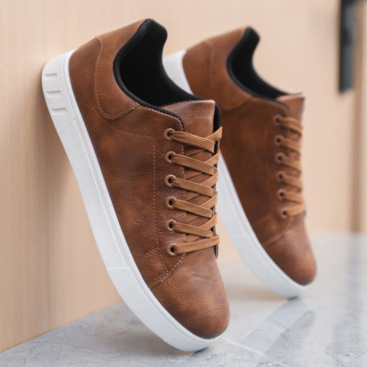Men's brown faux leather lace-up sneakers with a minimalist design and crisp white rubber soles.