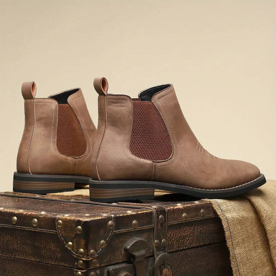 Distressed brown faux leather Chelsea boots with elastic side panels, pull tabs, and stacked block heels.