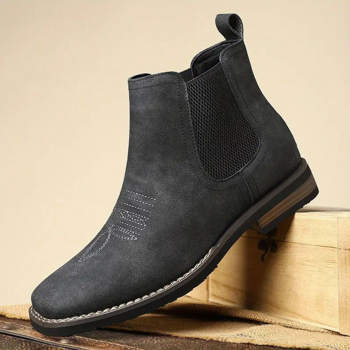 Black distressed faux leather Chelsea boot with western toe stitching, elastic side panels, and a stacked block heel.