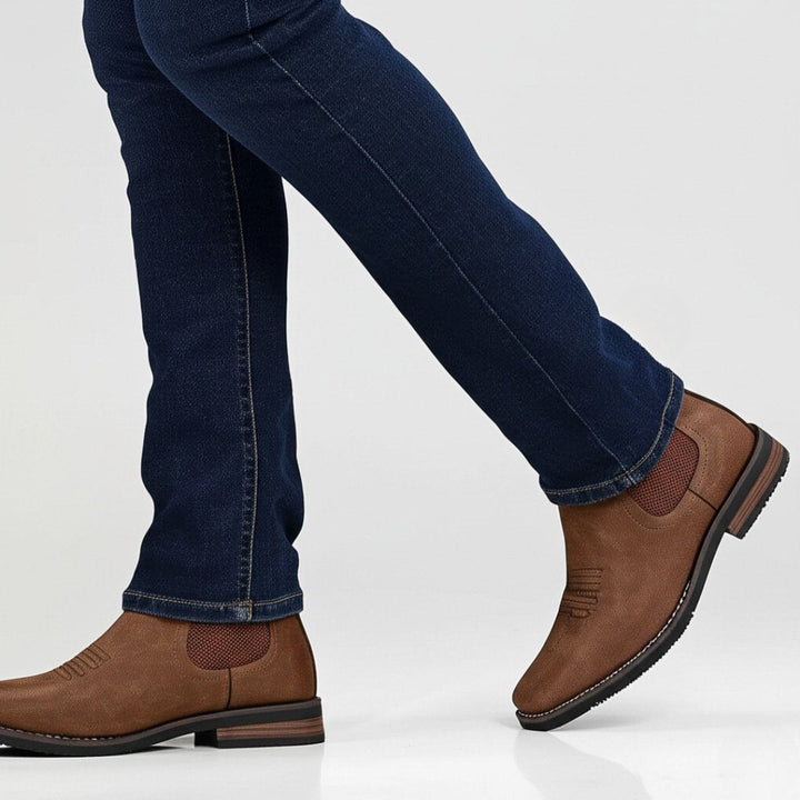 Distressed brown faux leather western Chelsea boots with elastic side panels, toe stitching, and a stacked block heel.