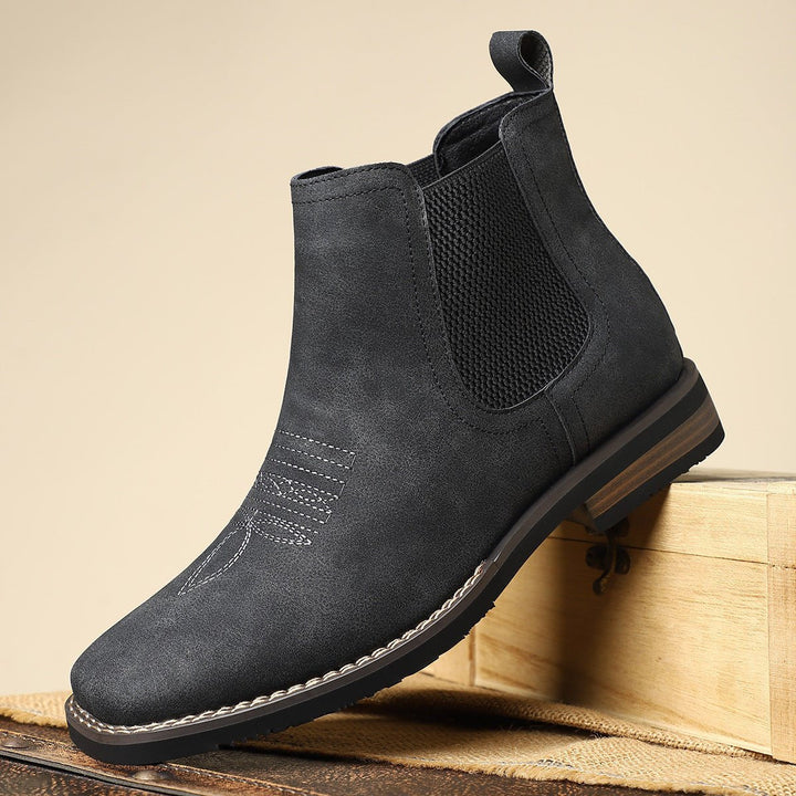 Black distressed faux leather Chelsea boot with western toe stitching, elastic side panels, and a stacked block heel.