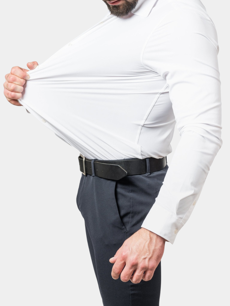 Man wearing a white slim-fit stretch dress shirt tucked into dark trousers, demonstrating the fabric's flexibility.