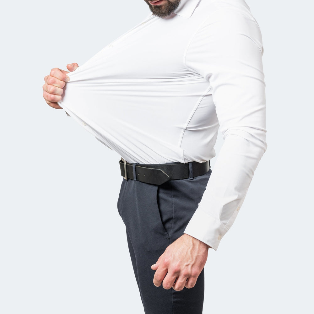 Man wearing a white slim-fit stretch dress shirt, demonstrating the flexible, high-stretch fabric of the material.