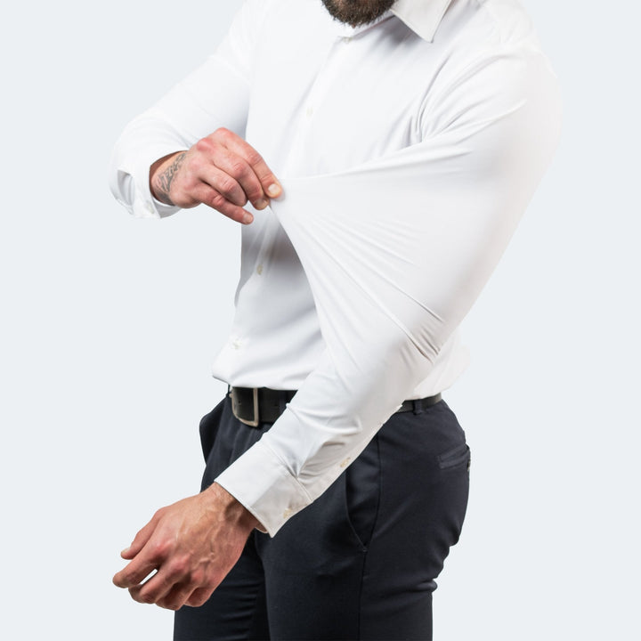 Man wearing a white slim-fit stretch dress shirt, demonstrating the flexible, high-stretch fabric of the sleeve.