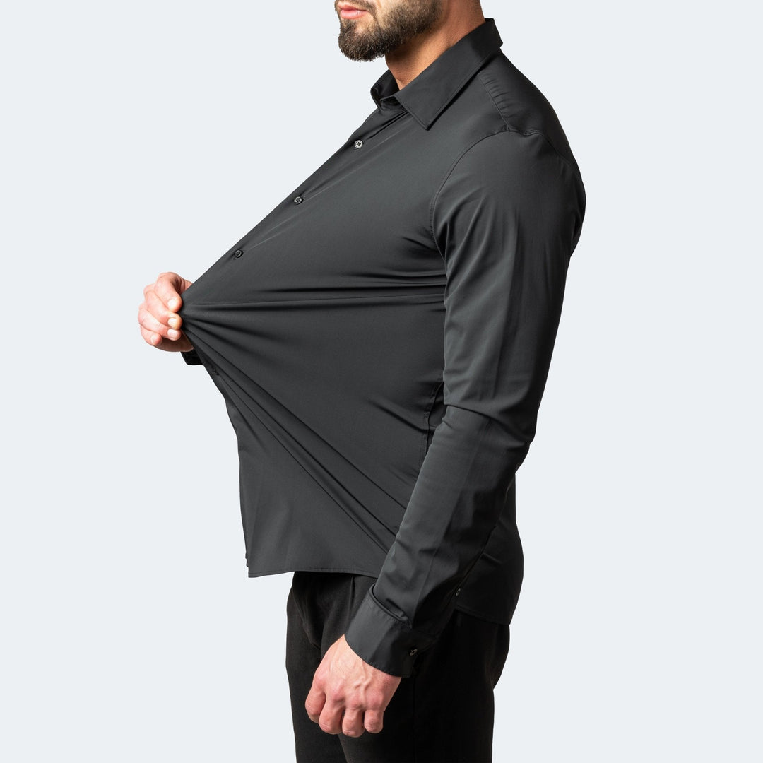 Man wearing a black slim-fit stretch shirt, demonstrating the flexible, high-stretch fabric with a button-down collar.