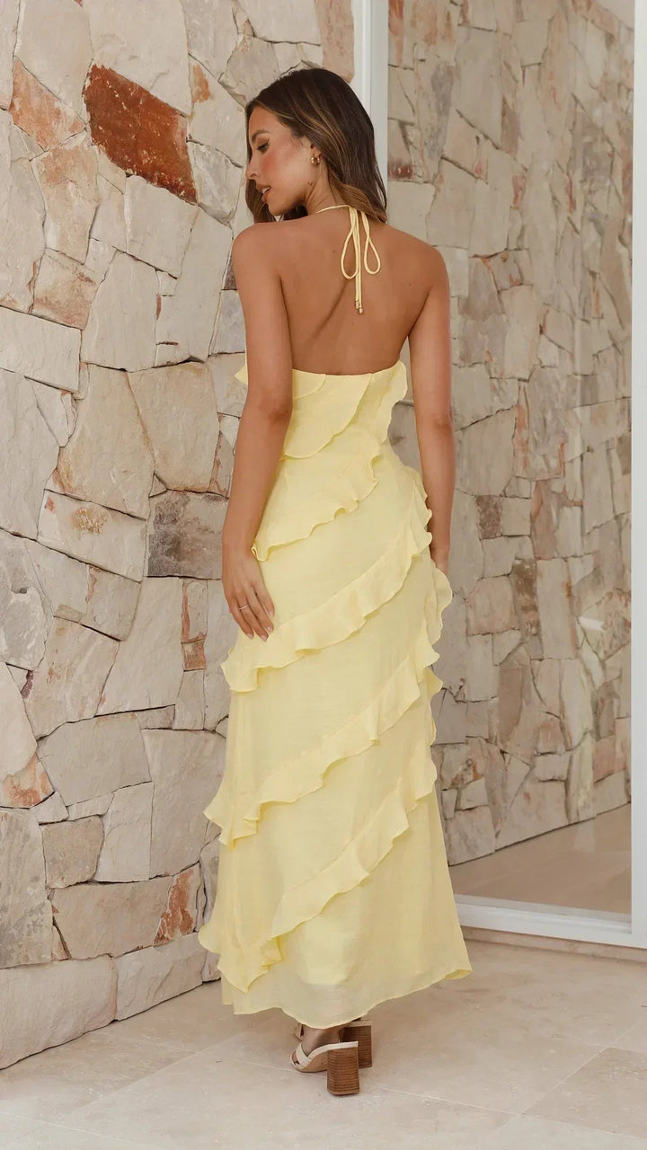 Women's yellow halter ruffle V-neck maxi dress with tie-back straps and cascading ruffles.