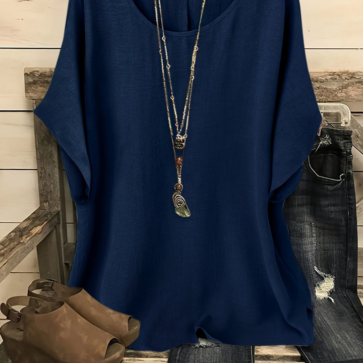 Navy blue linen-look round neck top with batwing sleeves and a layered pendant necklace.