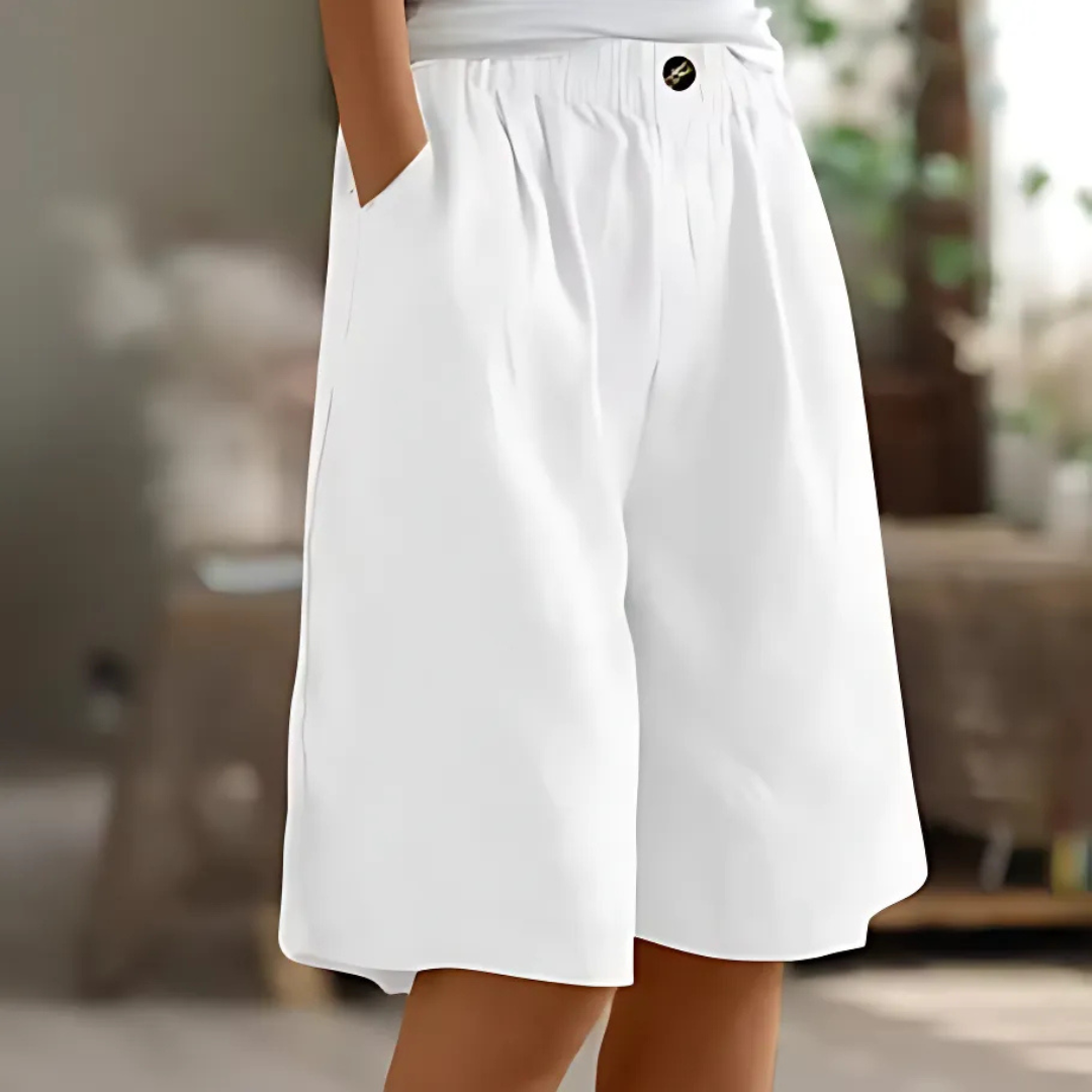 White Maisie women's elastic waist Bermuda shorts with pockets and a single button closure, perfect for relaxed sunny-day styling.